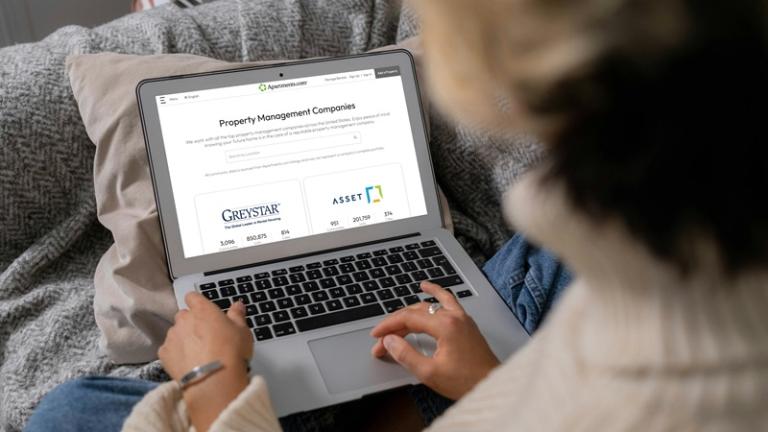 Woman browses directory of property management companies on Apartments.com