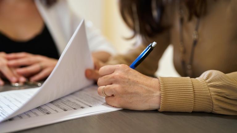 Close-up of woman signing a lease