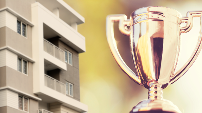 Winner's trophy with apartment building in background