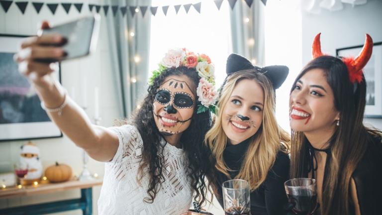 Three young women in costume take a selfie