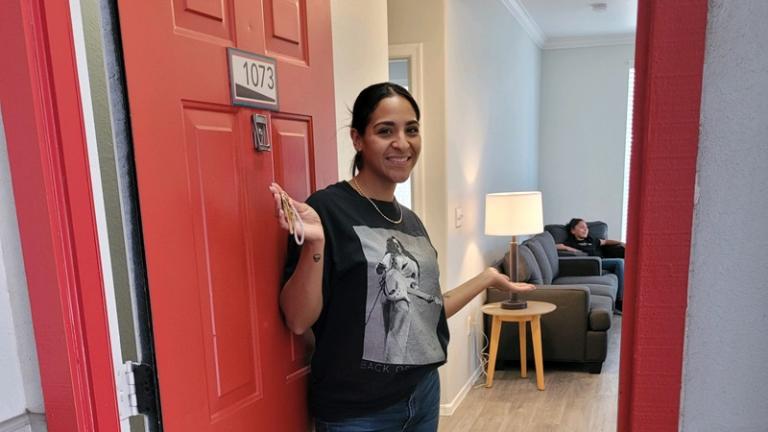 Entryway participant opens the door to her new apartment