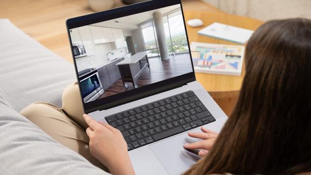 Woman clicks on 3D virtual tour on laptop