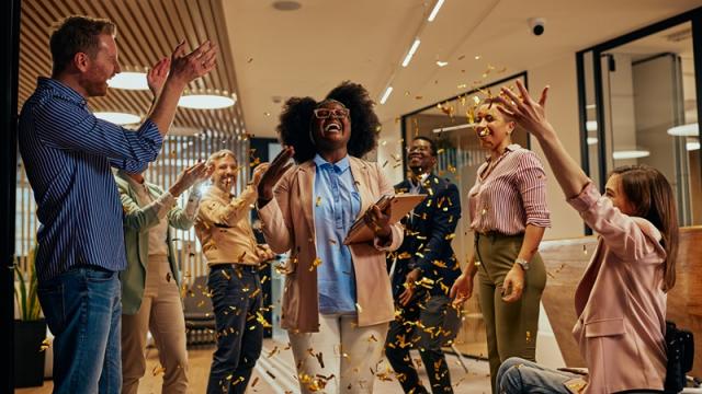 Colleagues celebrating employee with confetti