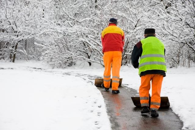 People shoveling a sidewalk