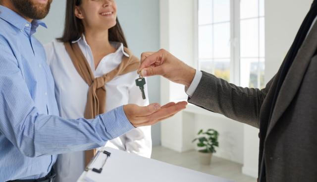 Landlord hands tenants keys to the rental property. 