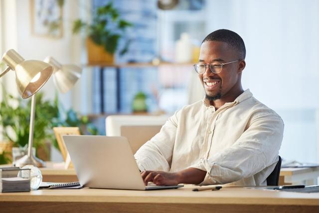 Man quickly replying to rental inquiries on his computer with a smile.