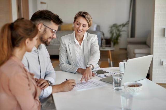 Landlord signing lease agreement with two tenants