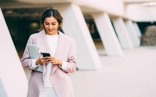 Professionally dressed woman looking at her phone.