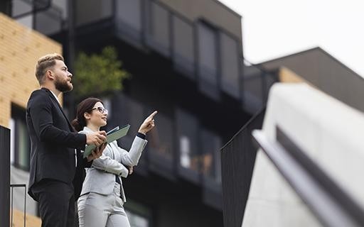 People discussing business in front of a property.