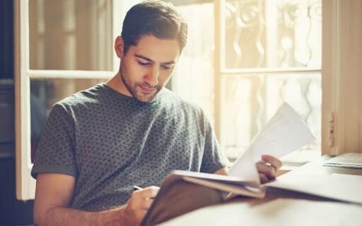 A man staring pensively at a journal