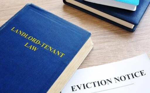 Book of lanlord-tenant law laying on an eviction notice