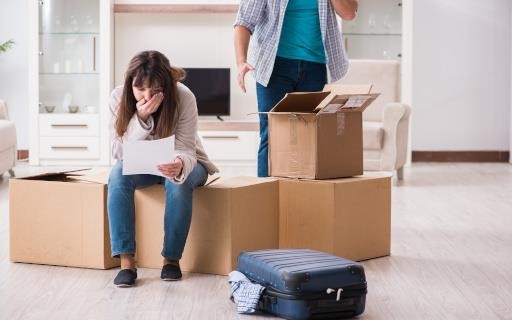 woman sitting on boxes and reading letter