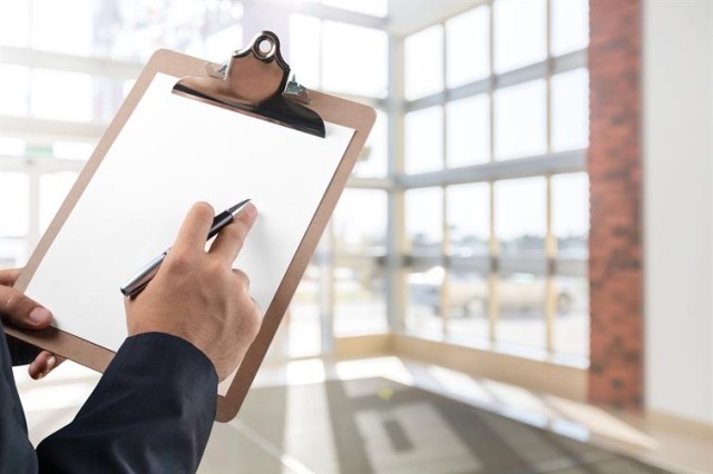 A professionally dressed person holding a clipboard