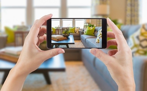 Person holding phone recording video of living room