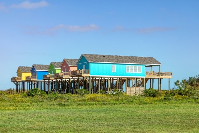 Colorful row of houses on stilts in the Texas flood zone